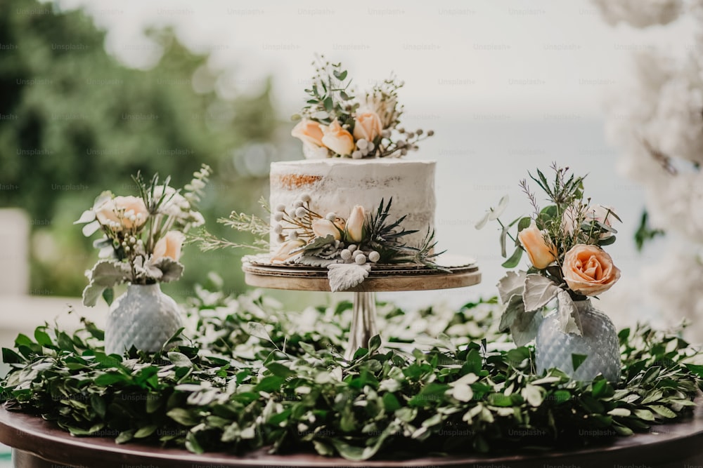 ein Tisch mit einem mit Blumen bedeckten Kuchen