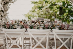 uma mesa montada com taças de vinho e flores