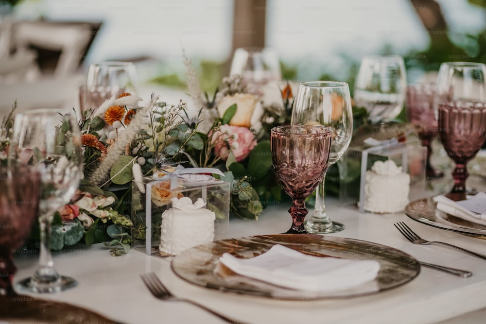 Une table est dressée avec des verres à vin et des assiettes