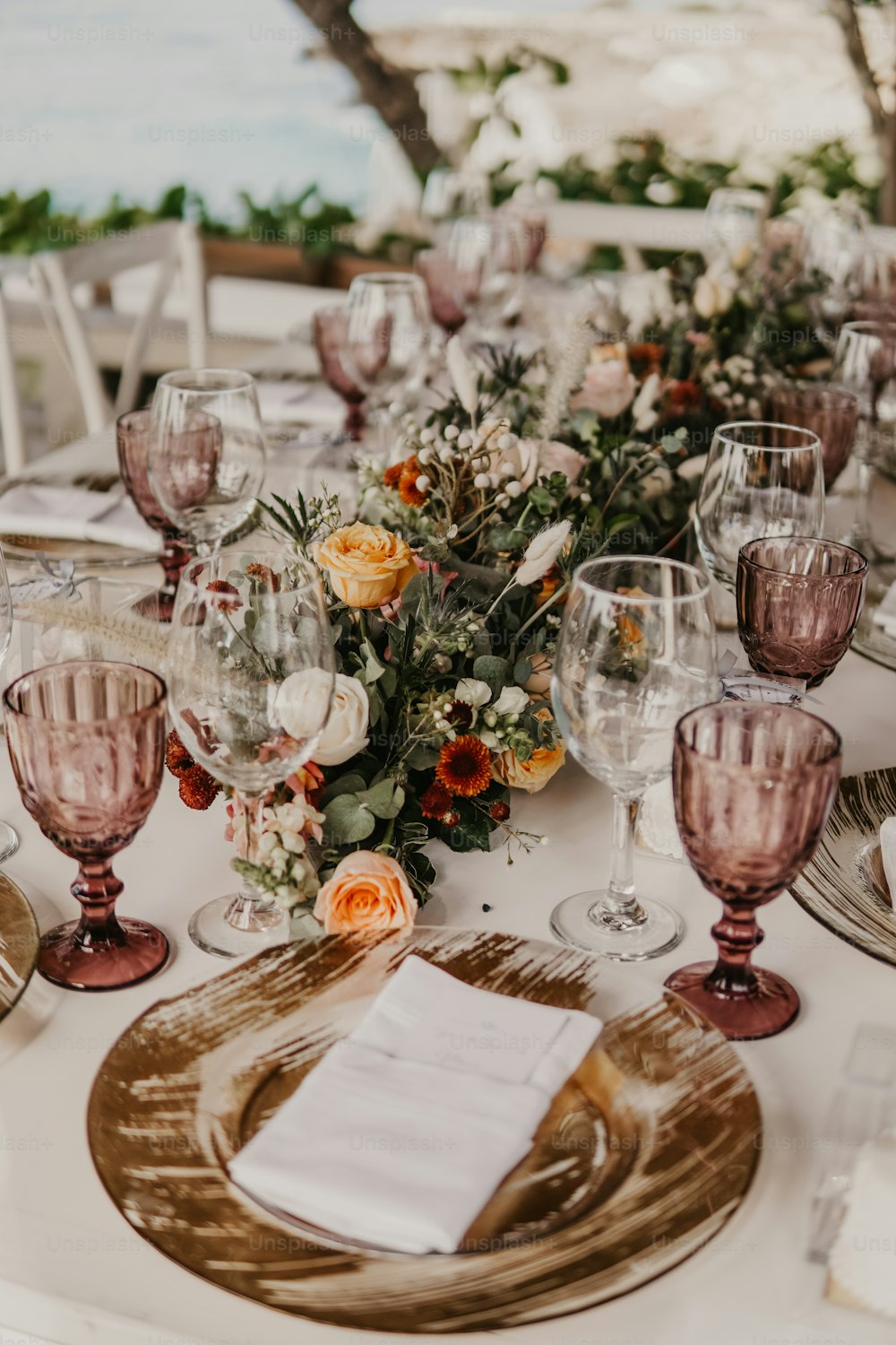 una tavola è apparecchiata con bicchieri da vino, piatti e tovaglioli