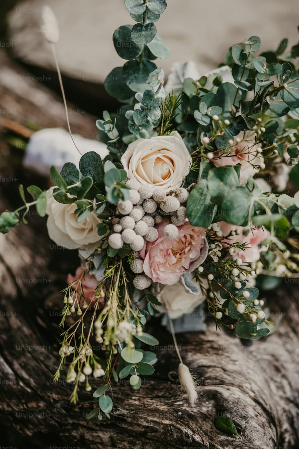 a bouquet of flowers sitting on top of a tree trunk