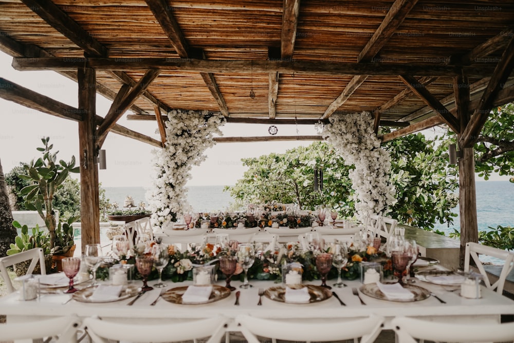 ein Tisch für eine Hochzeit mit Blumen und Grün
