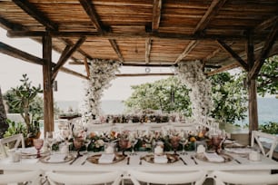 Une table dressée pour un mariage avec des fleurs et de la verdure
