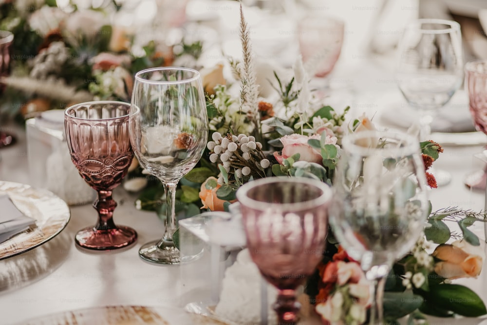 un primo piano di un tavolo con bicchieri e fiori