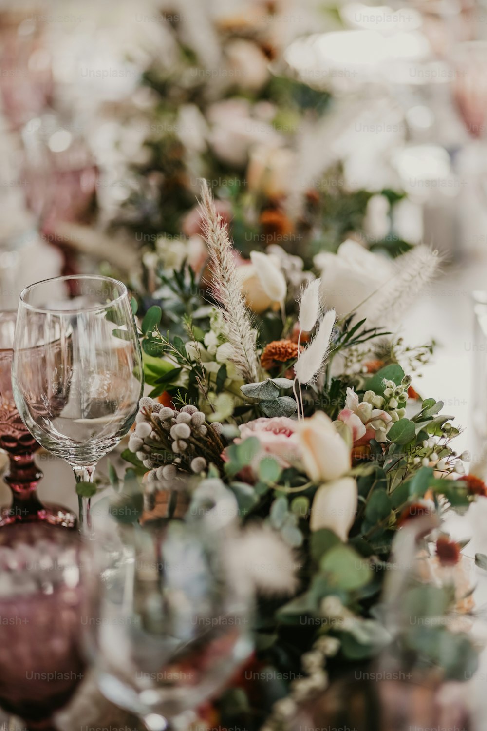 a close up of a table with wine glasses and flowers