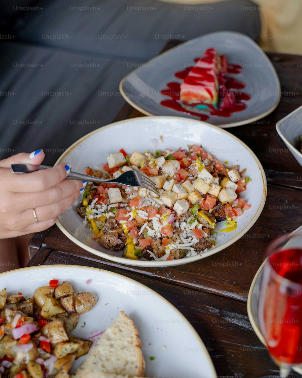 a table with plates of food and a glass of wine