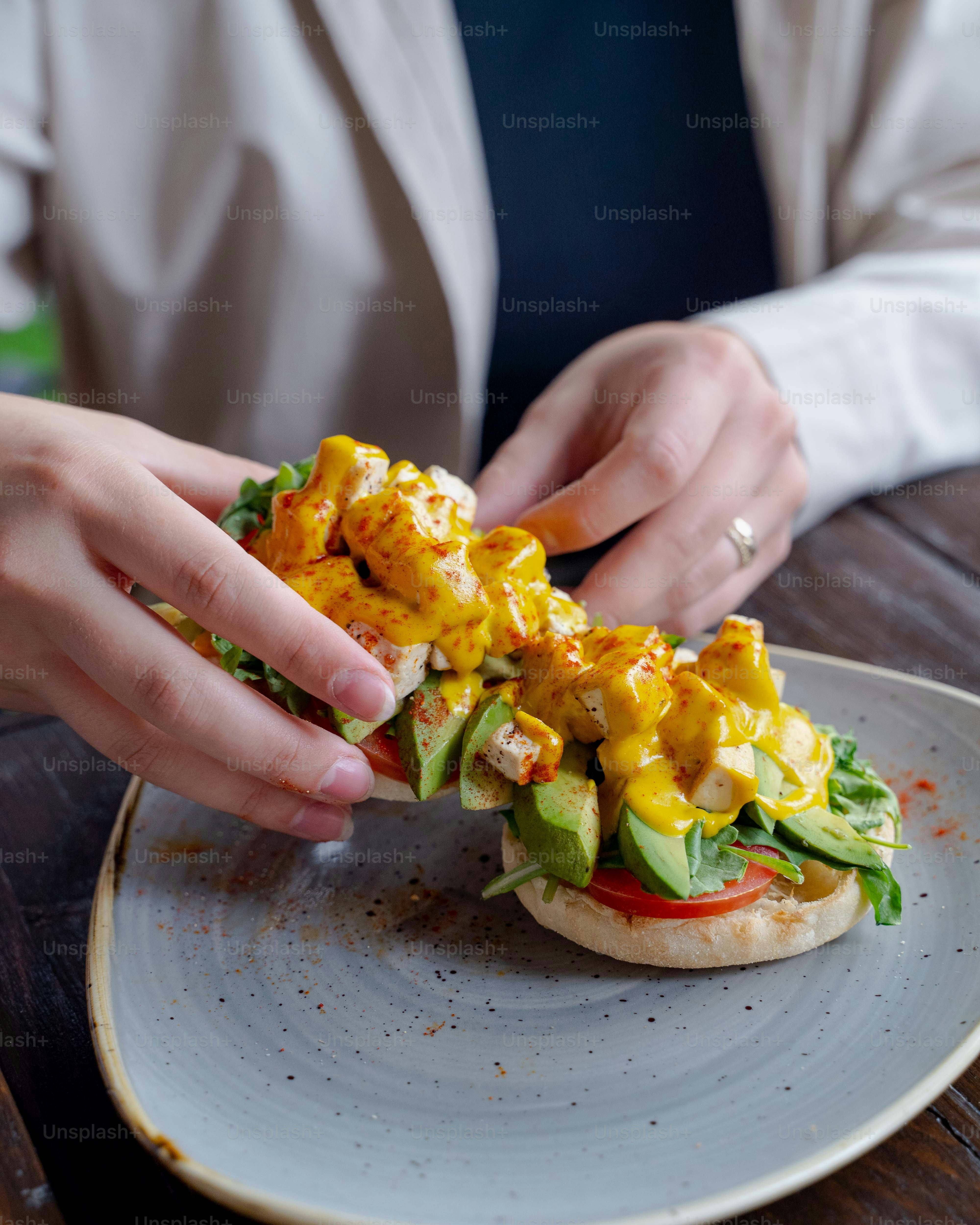 una persona sta mangiando un panino su un piatto