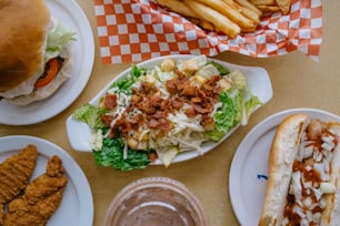 Una mesa cubierta con platos de comida y papas fritas