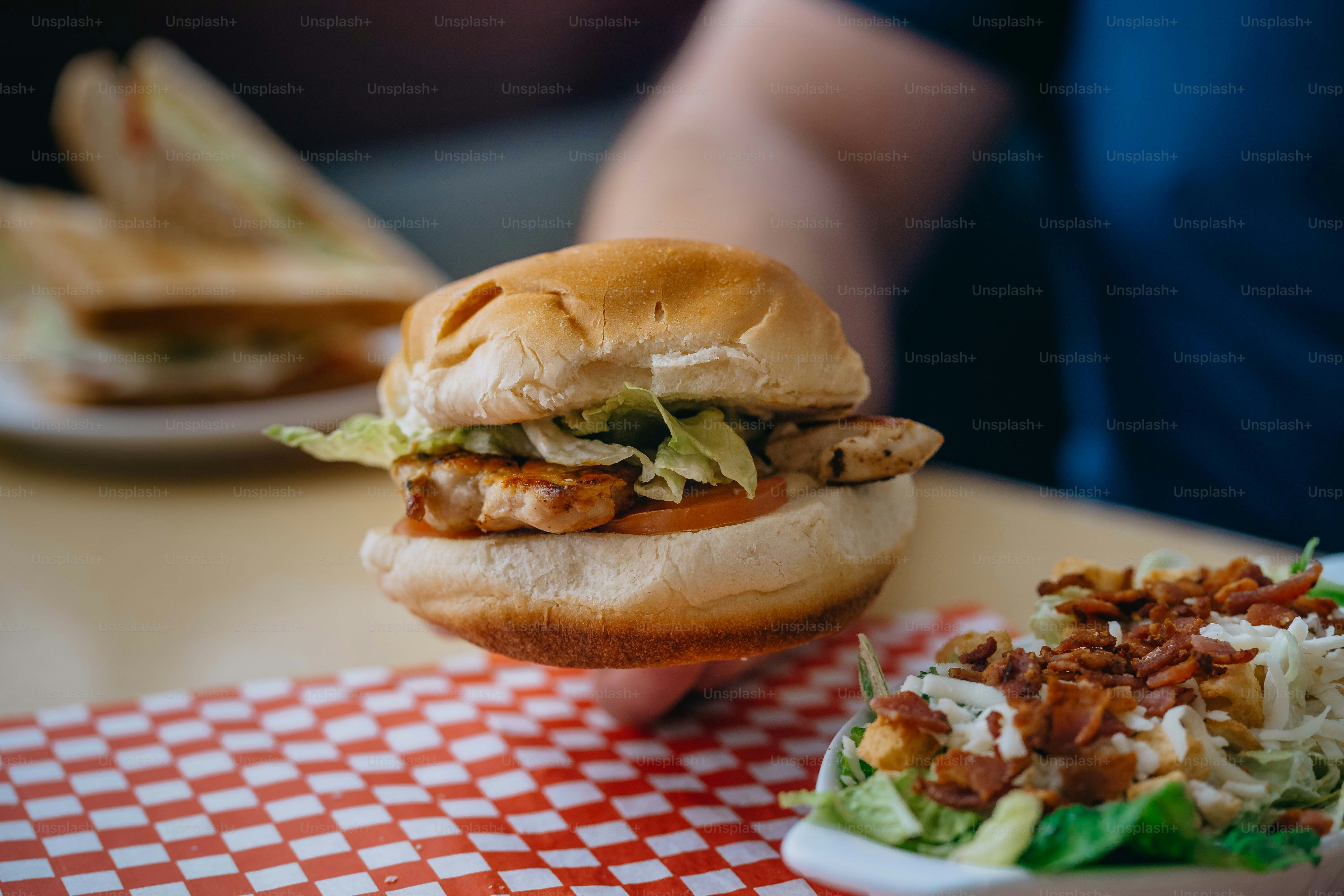 a chicken sandwich with lettuce and a side of coleslaw