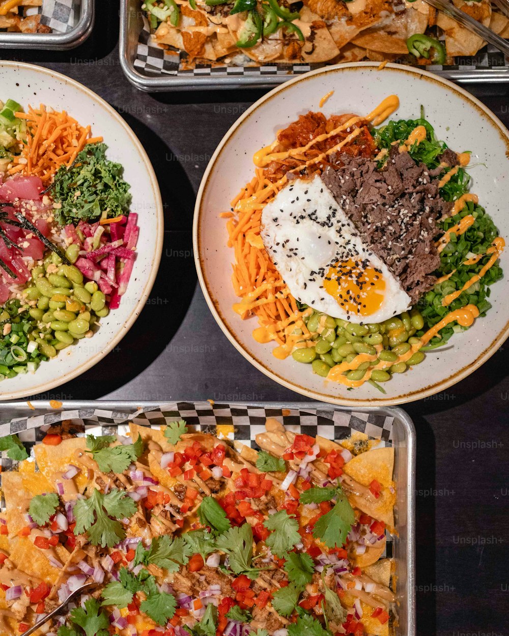 ein Tisch mit Tellern, die mit verschiedenen Arten von Lebensmitteln gefüllt sind