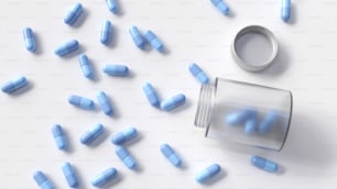 blue pills scattered around a pill bottle on a white surface