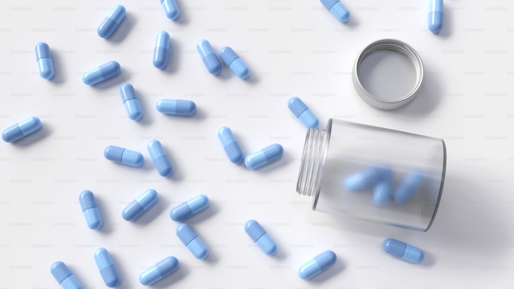 Pillole blu sparse intorno a una bottiglia di pillola su una superficie bianca