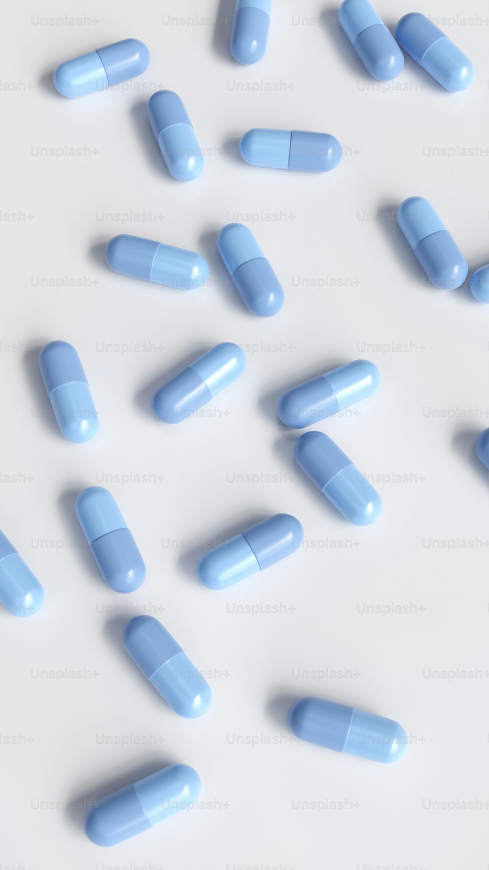 Le pillole blu sono sparse su una superficie bianca