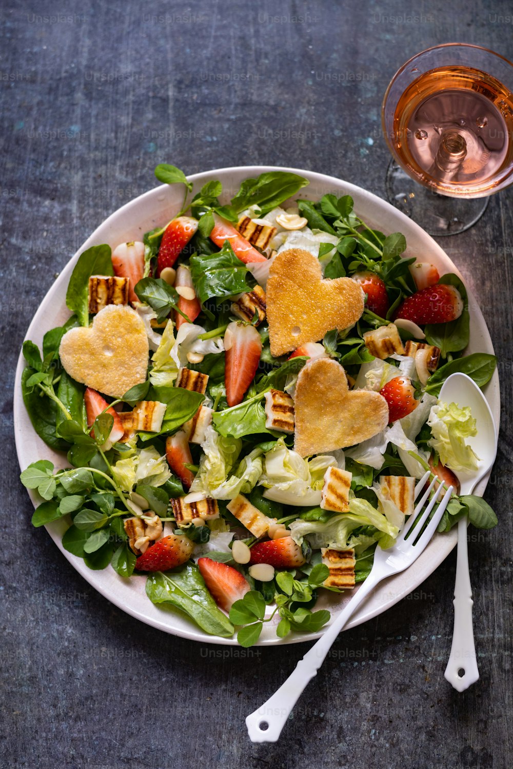 a plate of salad with heart shaped appetizers