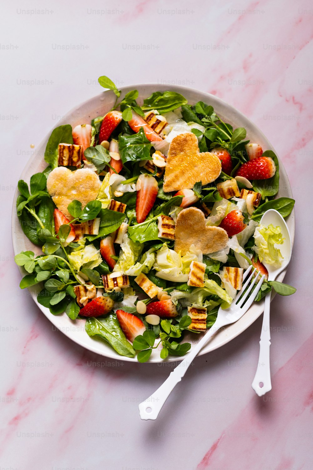 un piatto bianco sormontato da un'insalata ricoperta di frutta