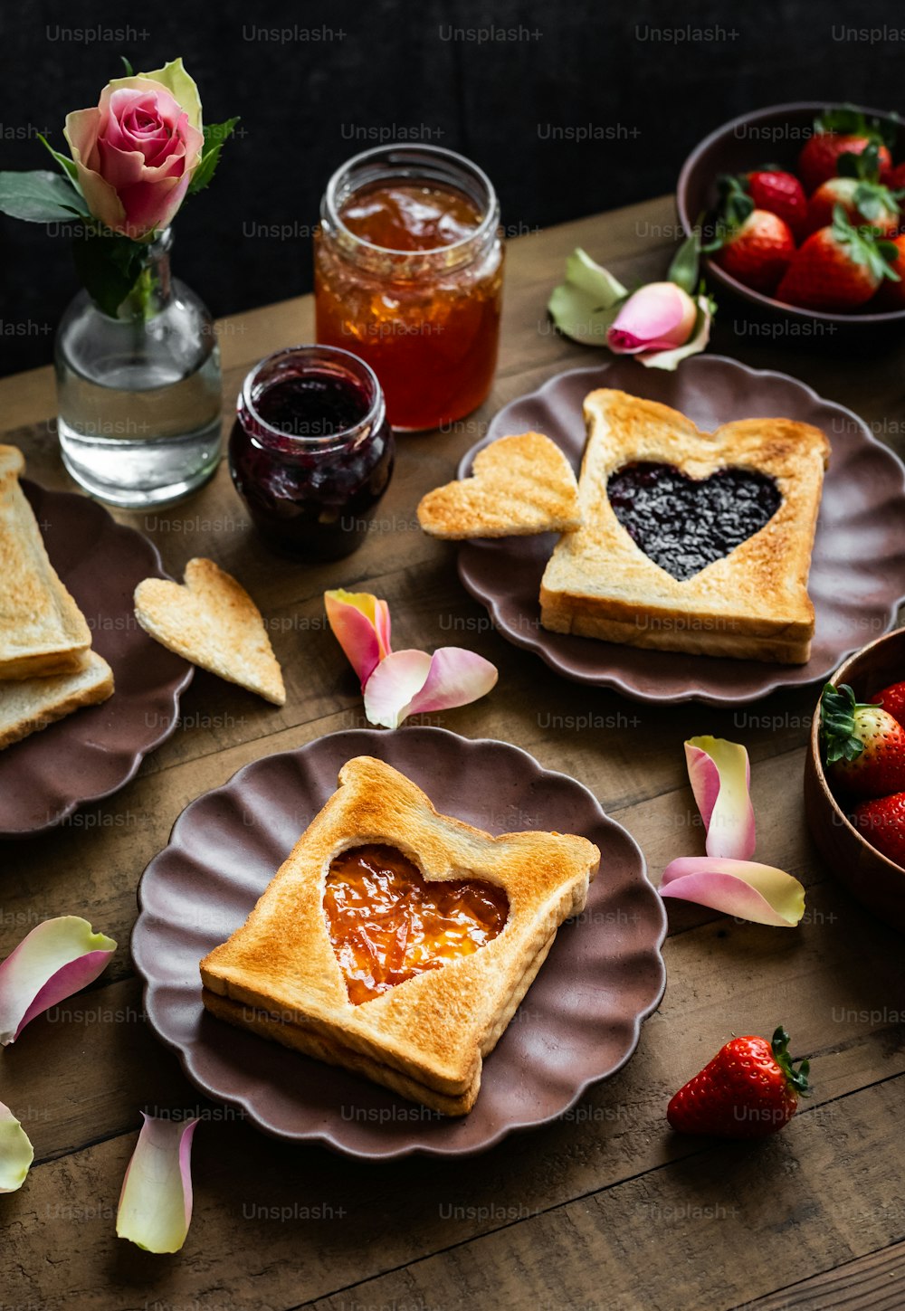 a wooden table topped with two heart shaped sandwiches