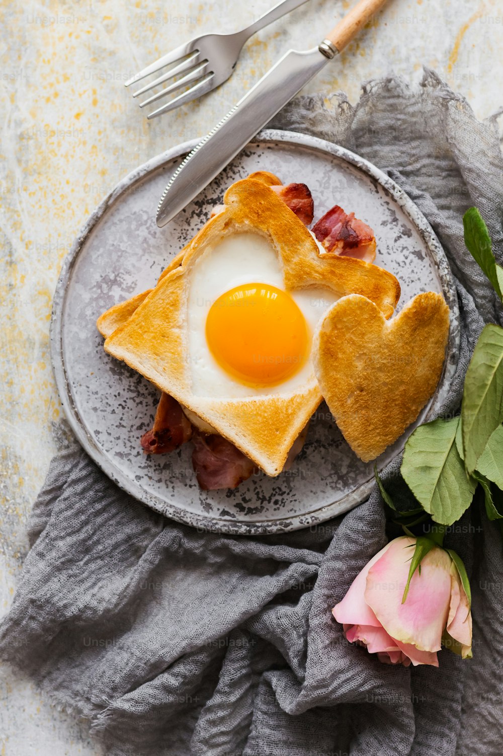 a plate of food with a heart shaped egg on it