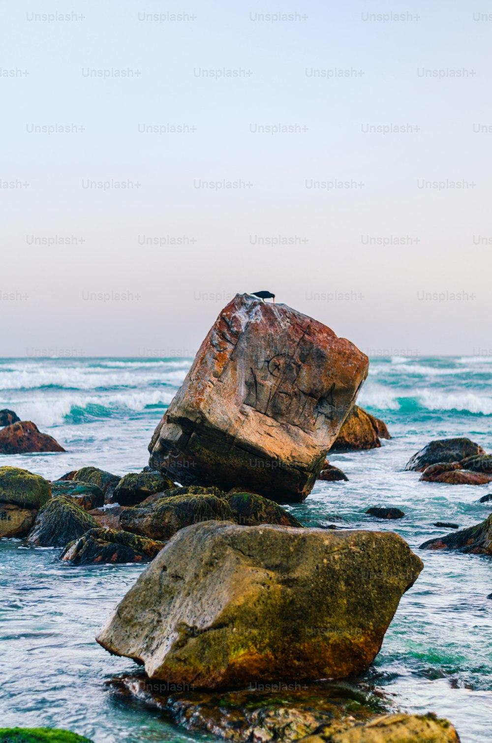 uma grande rocha sentada em cima de um corpo de água