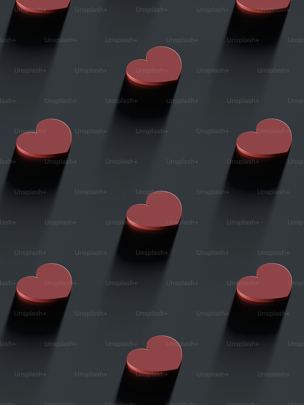 Un gruppo di cuori rossi seduti sopra una superficie nera