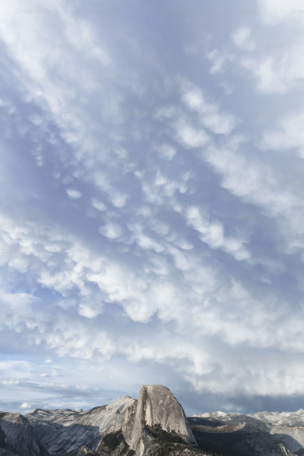 uma vista de uma cordilheira com nuvens no céu