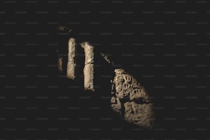 Un pilar de piedra con tallas en la oscuridad