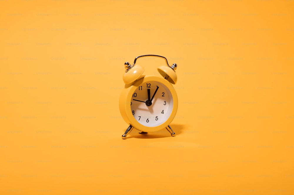 a yellow alarm clock on a yellow background
