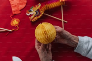 a person holding a yellow paper ball on a stick