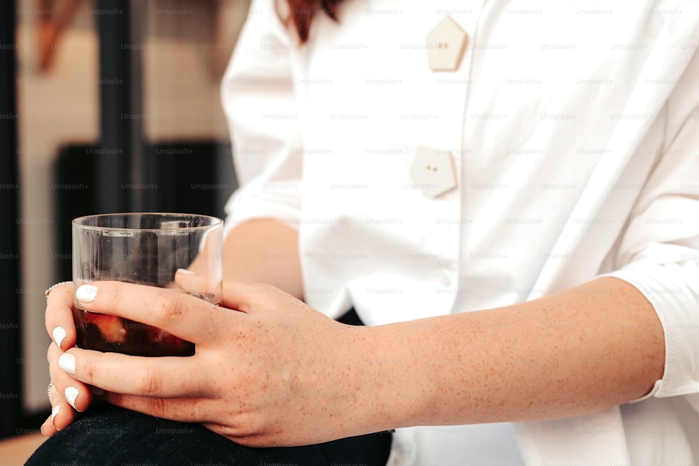 Eine Frau sitzt mit einem Glas Wein in der Hand