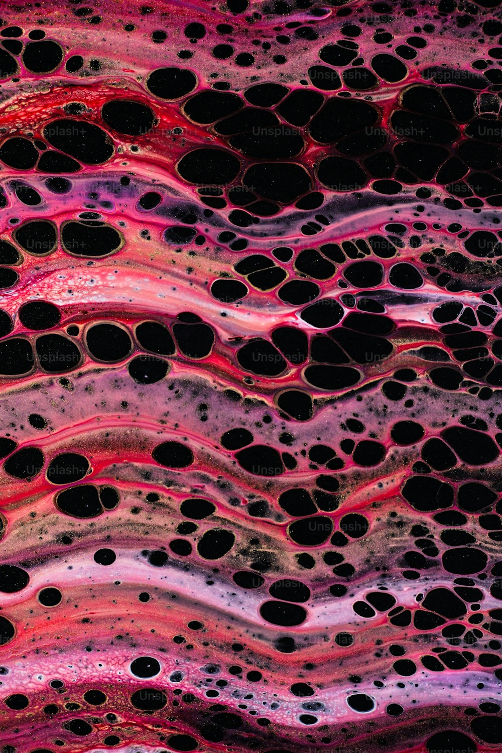 a close up of a pink and black substance