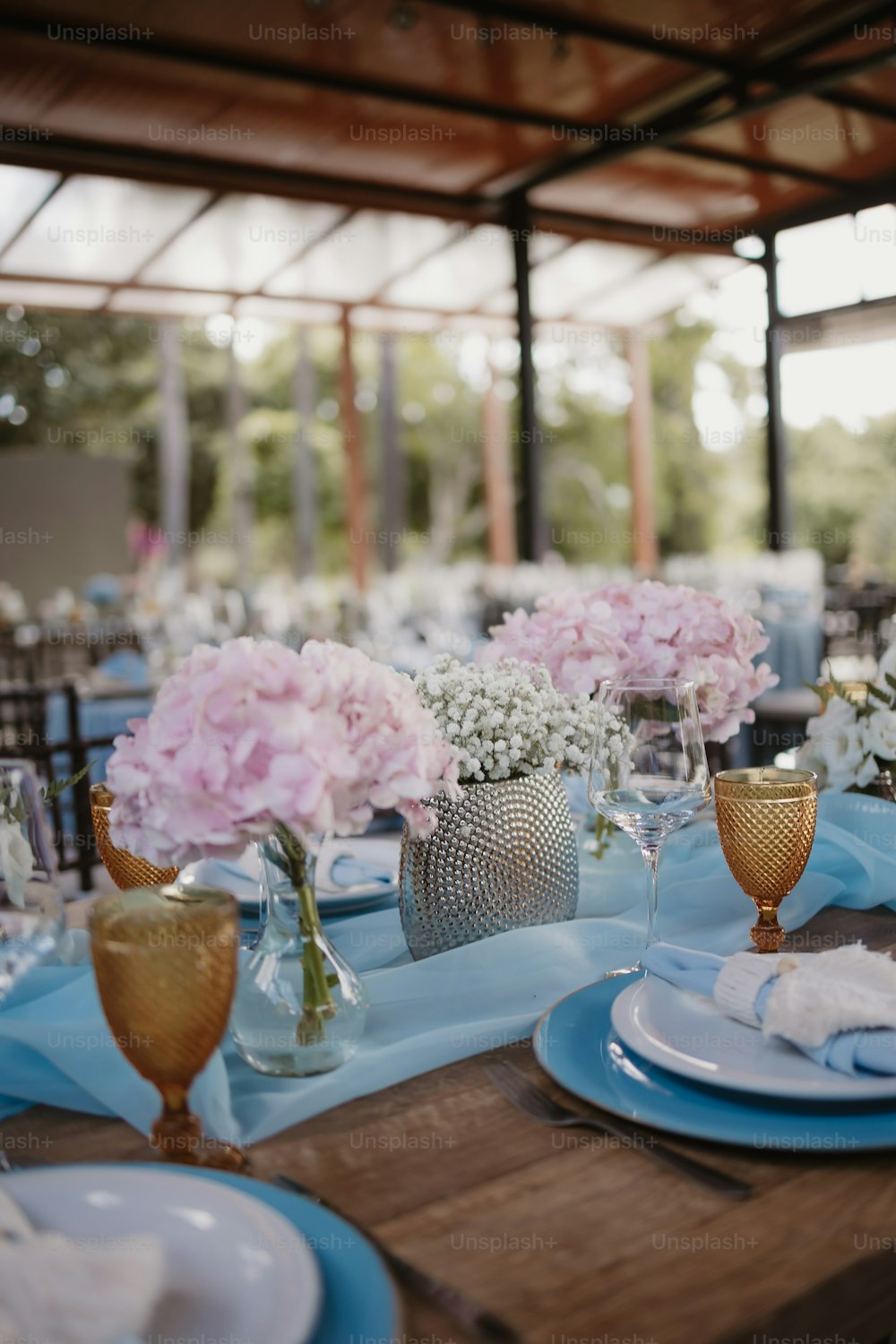 a table set with blue and white plates and flowers