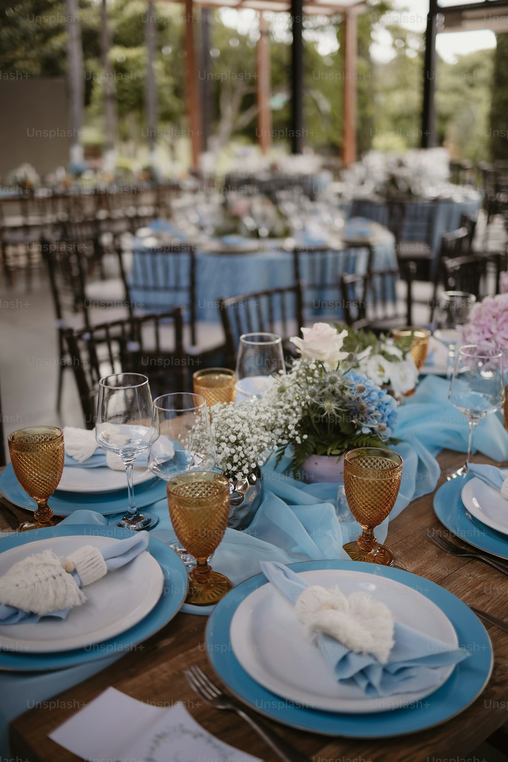 Una mesa configurada con platos azules y blancos y ajustes de lugar