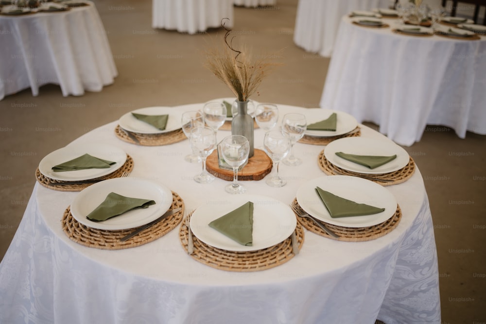 a white table topped with plates and place settings