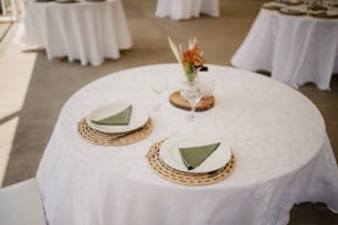 a white table topped with plates and a vase filled with flowers