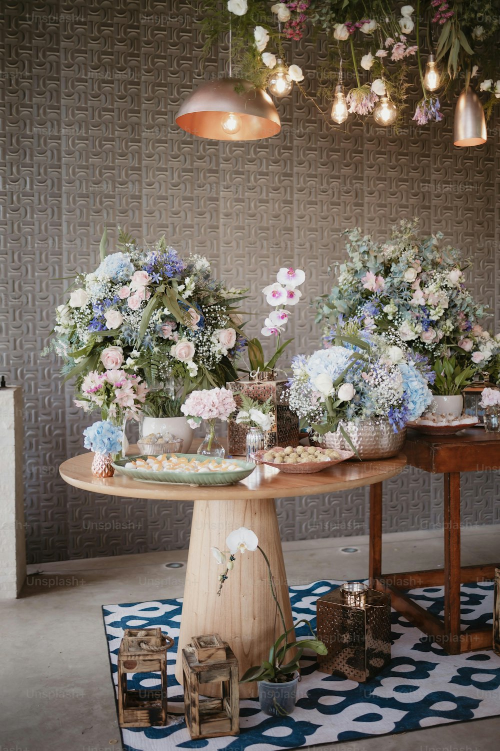 a table topped with lots of flowers on top of a rug