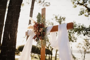 a cross decorated with flowers and ribbons