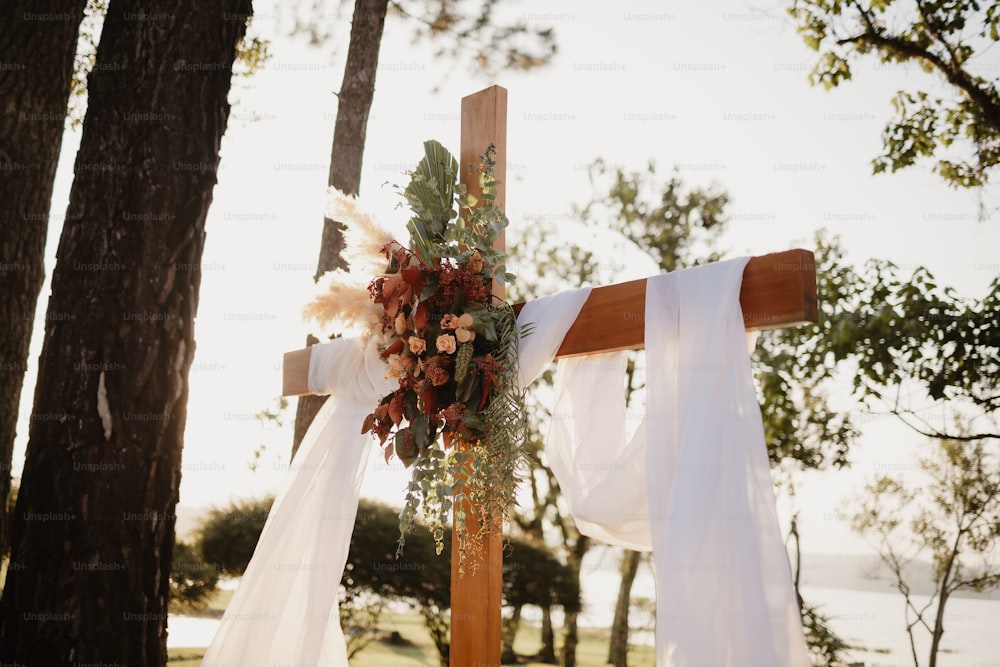 a cross decorated with flowers and ribbons