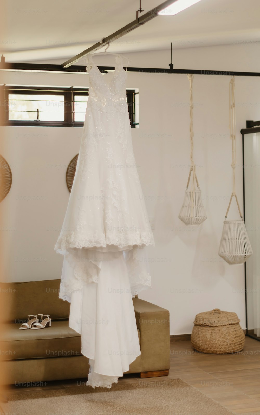 a wedding dress hanging on a hanger in a room