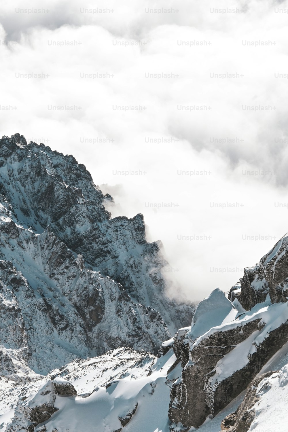 Un homme debout au sommet d’une montagne enneigée