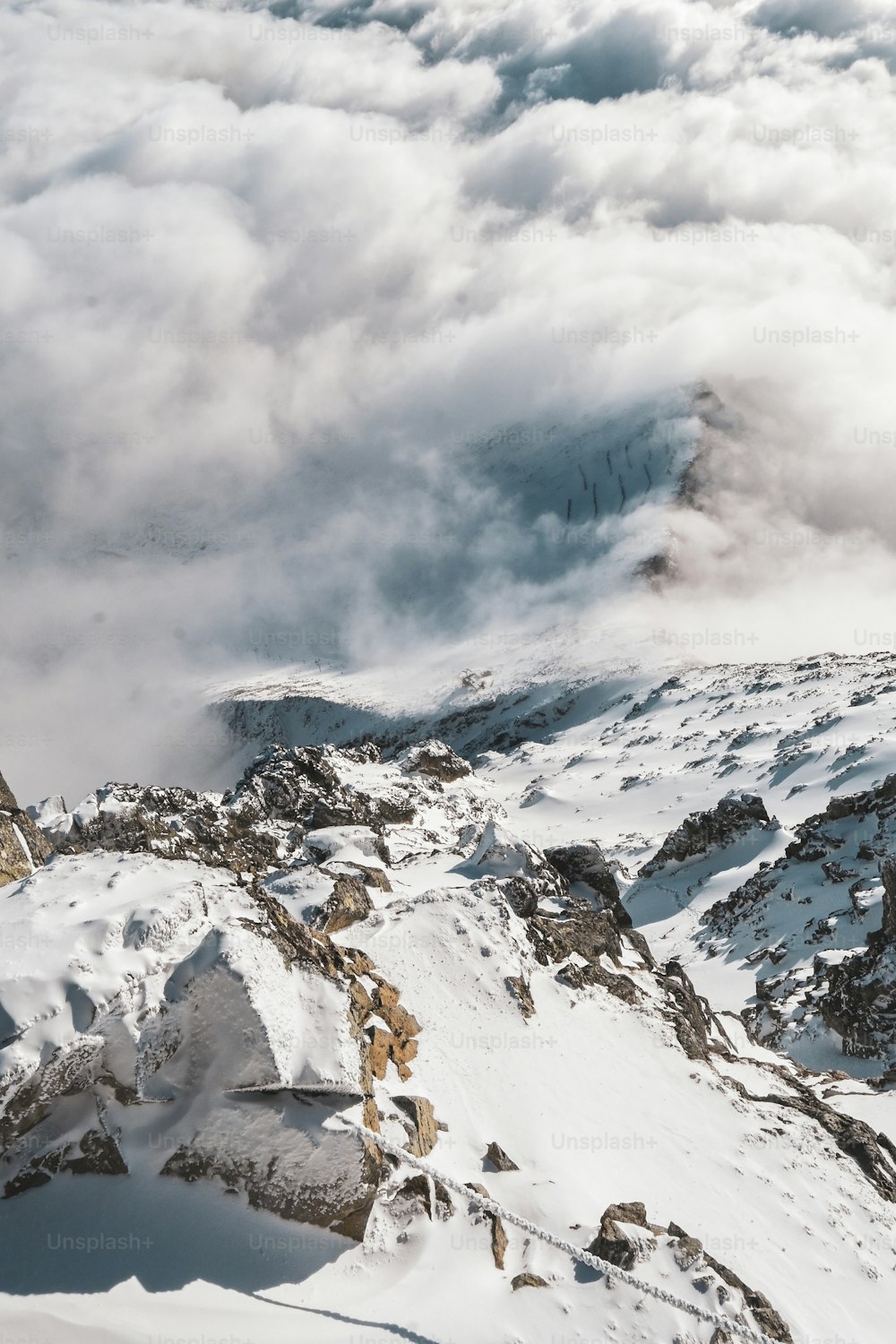 Une montagne couverte de neige et de nuages au loin