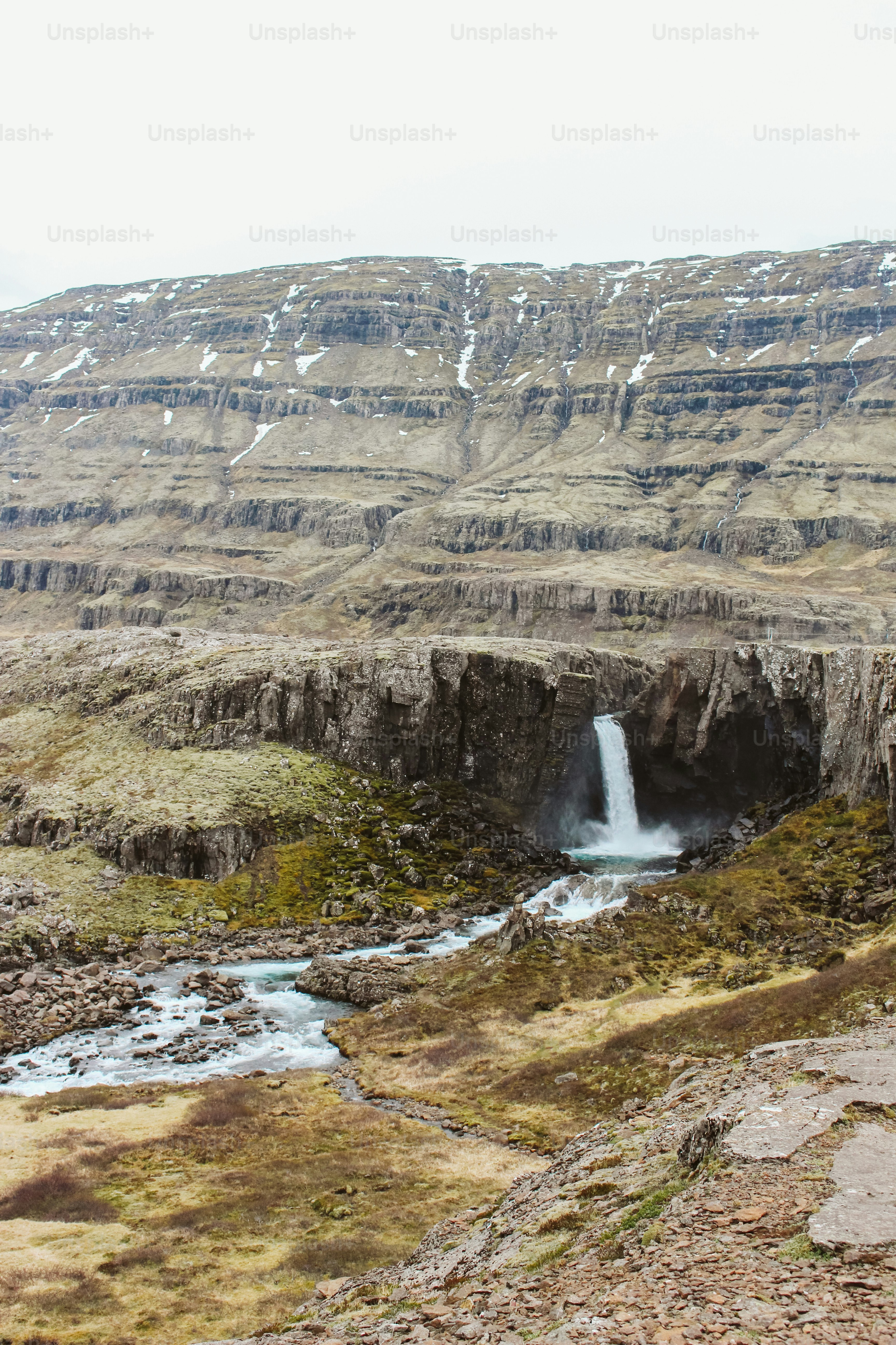 A man standing in front of a waterfall photo – Mountains Image on Unsplash