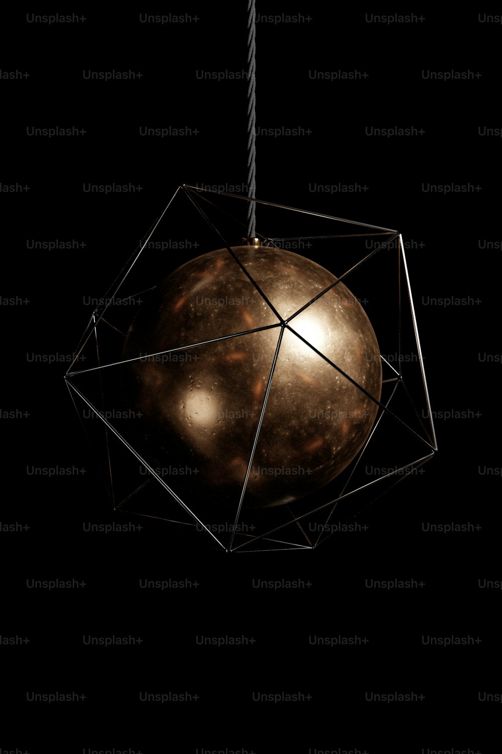 a sphere hanging from a string on a black background