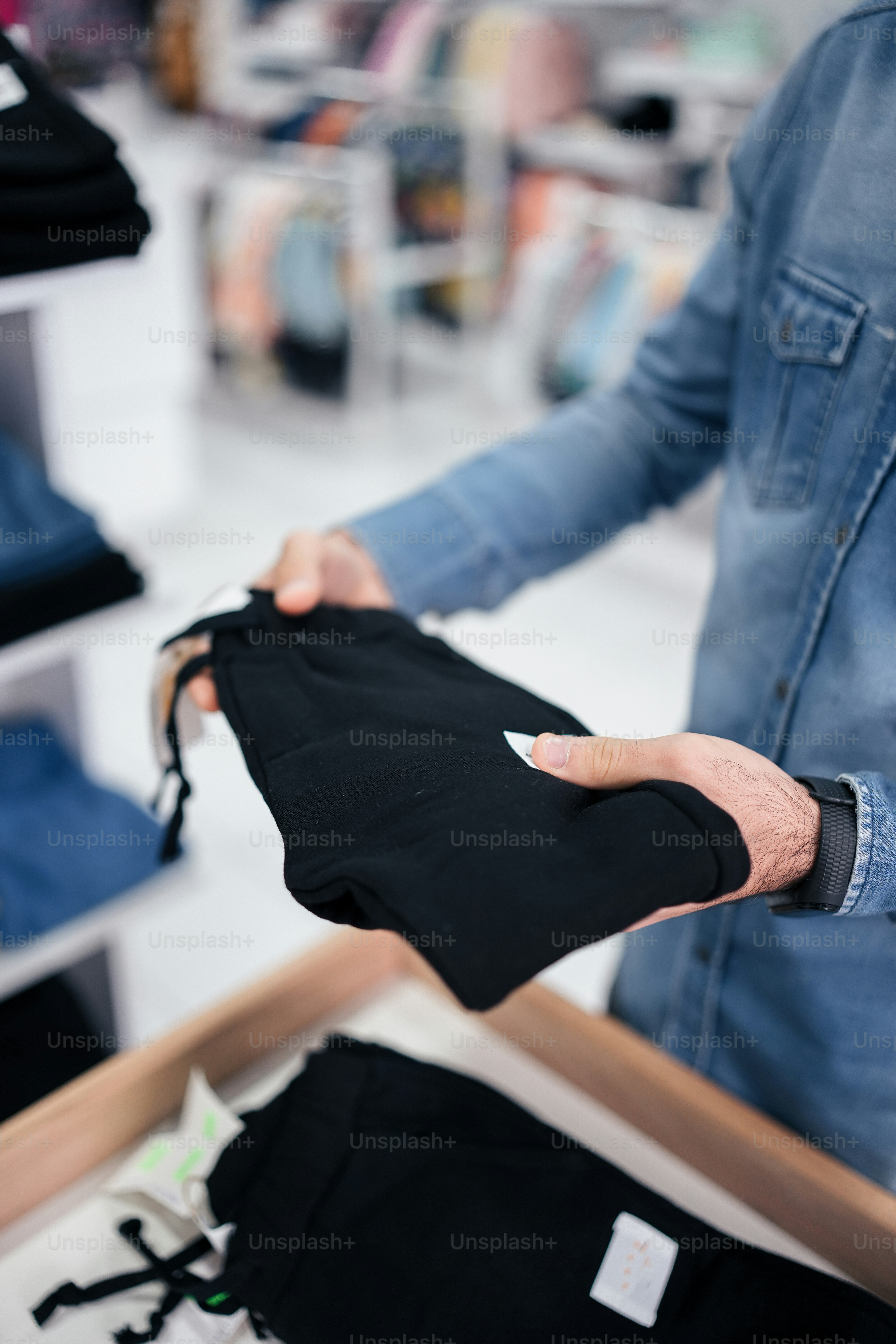 a person holding a black jacket in a store