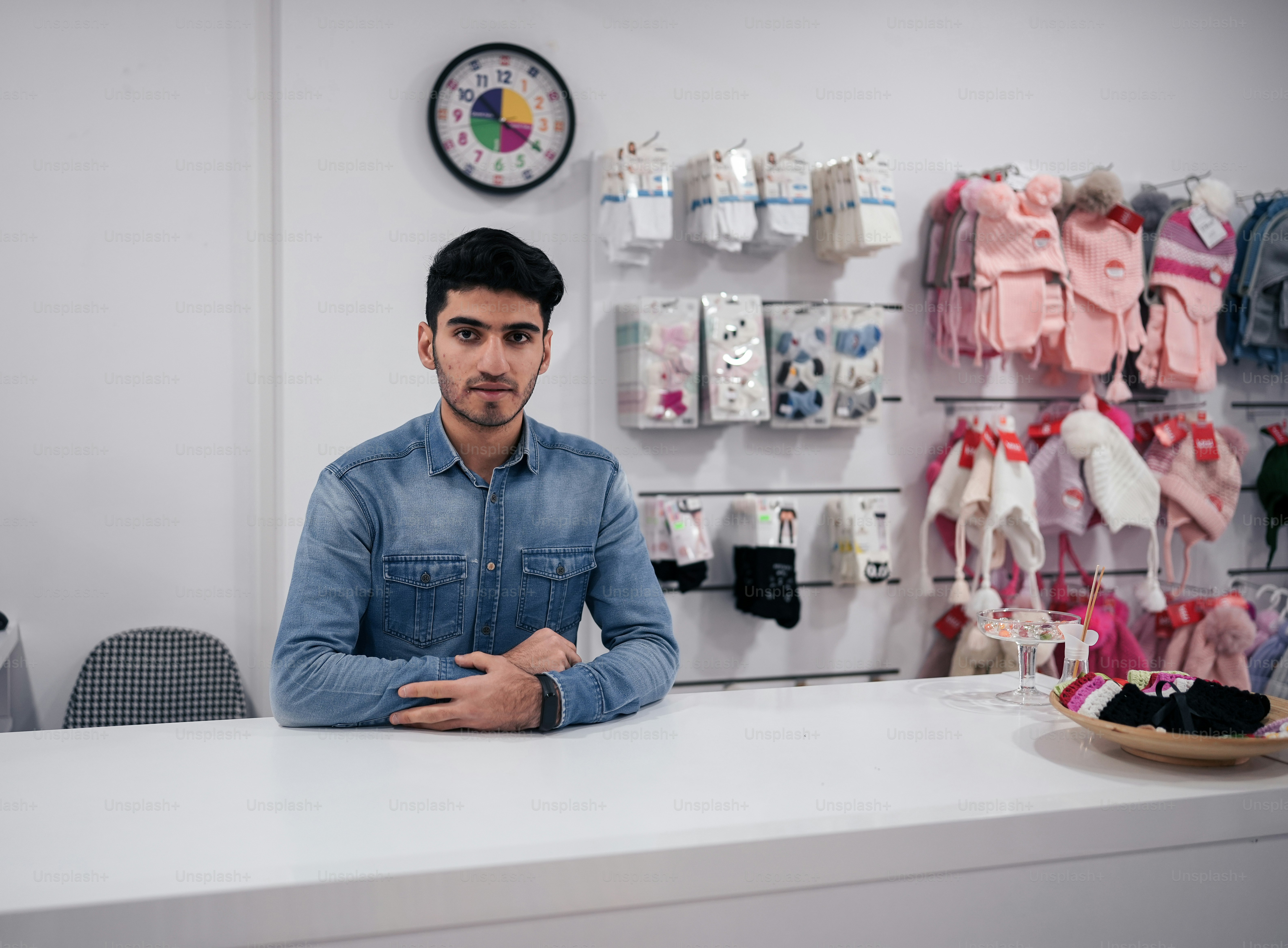 a man sitting at a counter in a clothing store