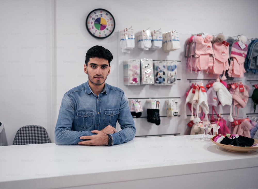 a man sitting at a counter in a clothing store