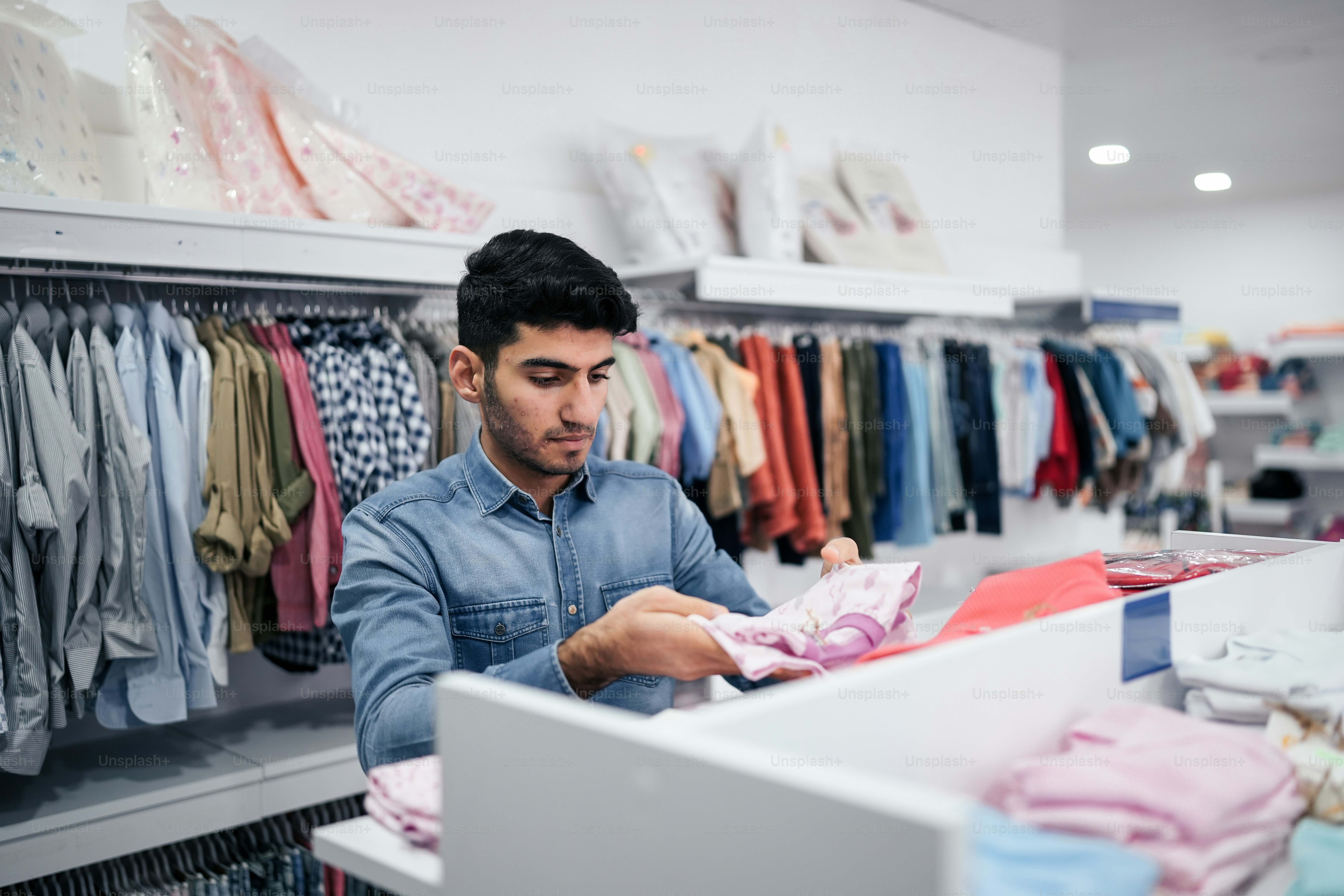 a man looking at a shirt in a closet