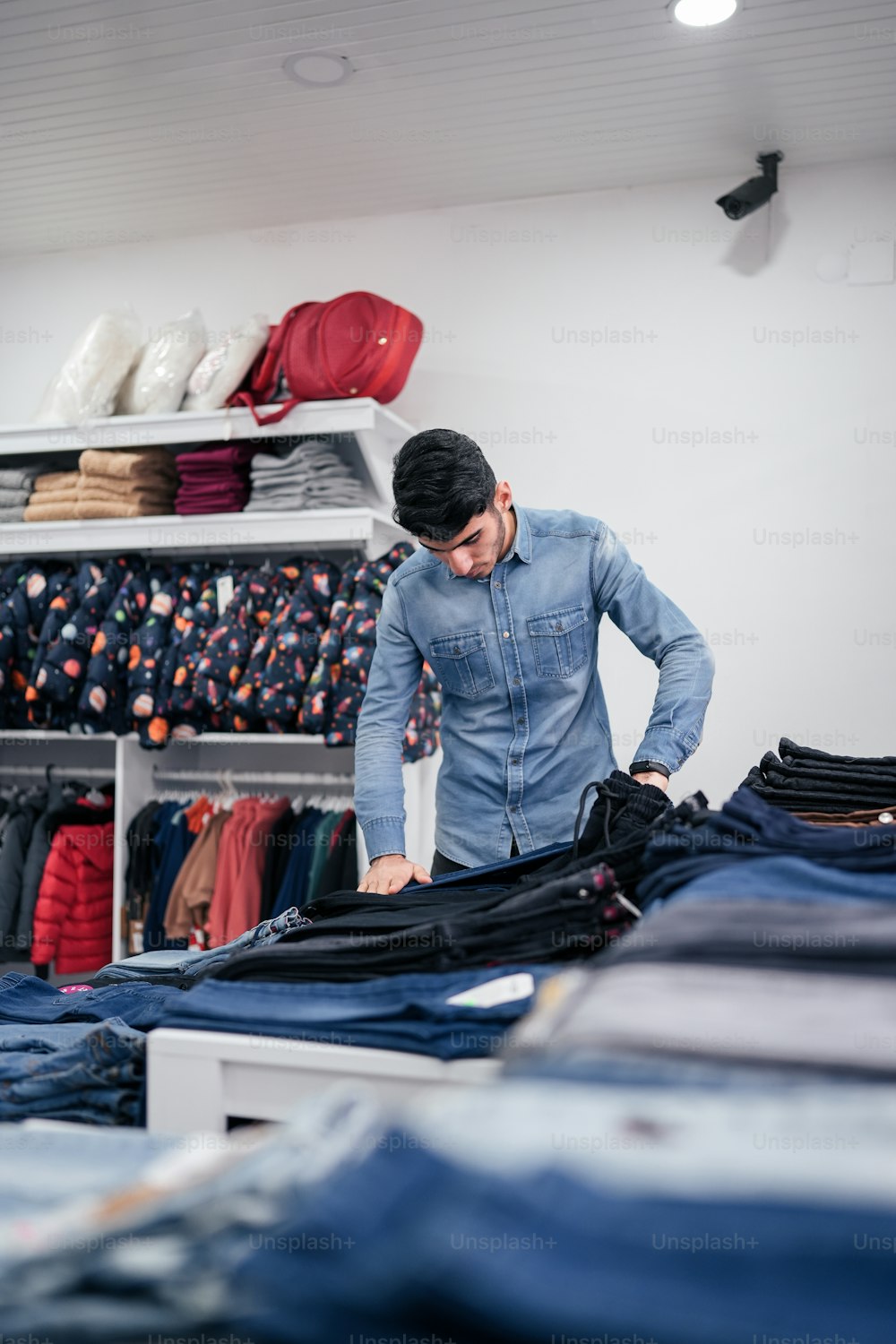 a man standing in front of a rack of clothes