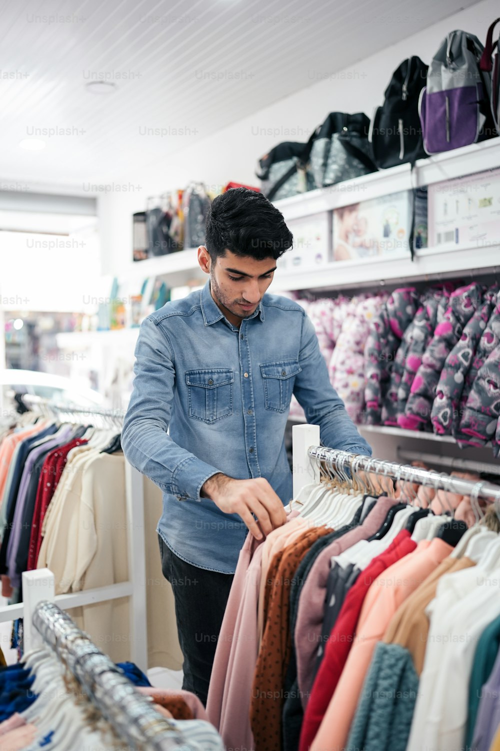 Un hombre mirando una camisa en una tienda