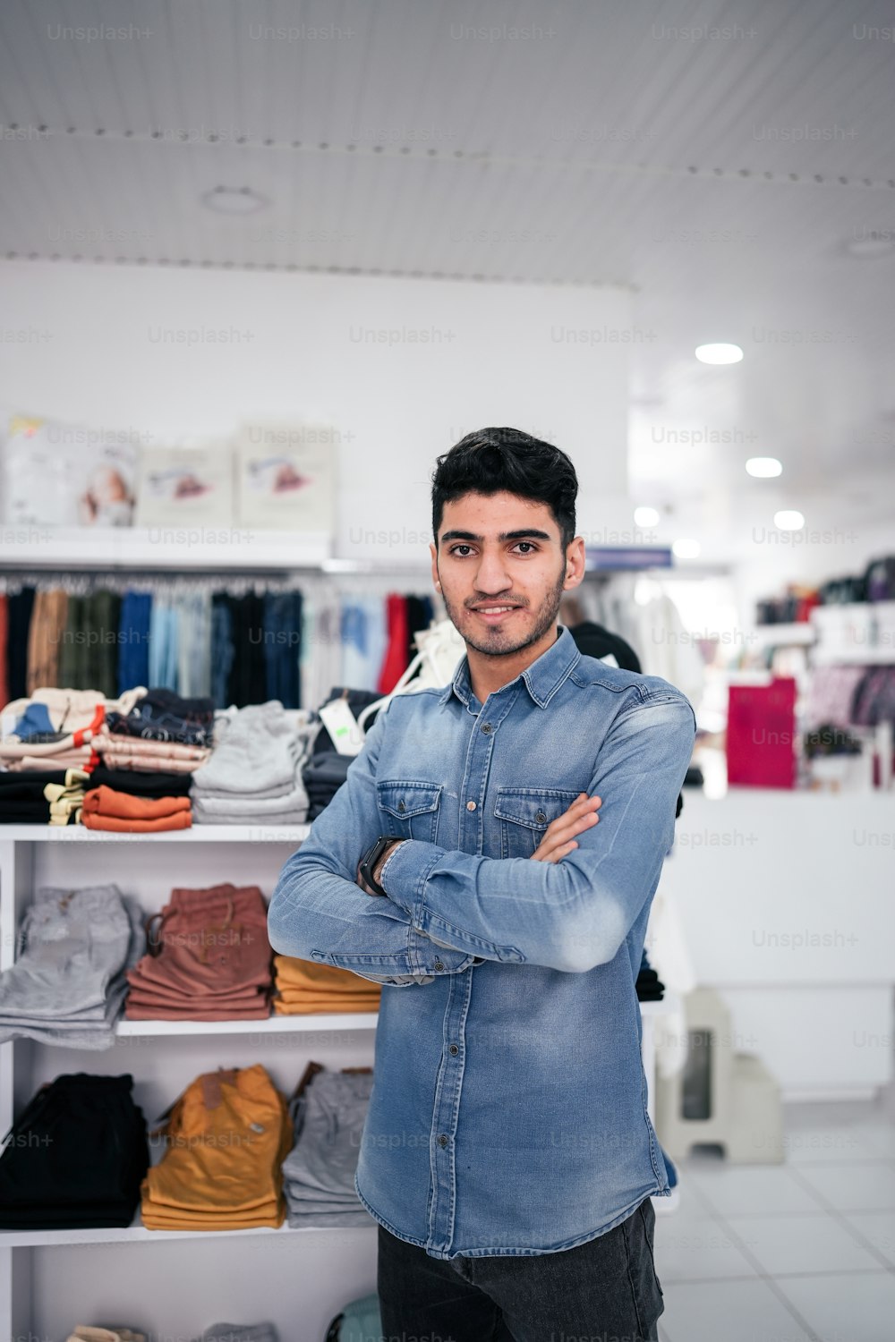 a man standing in front of a rack of clothes