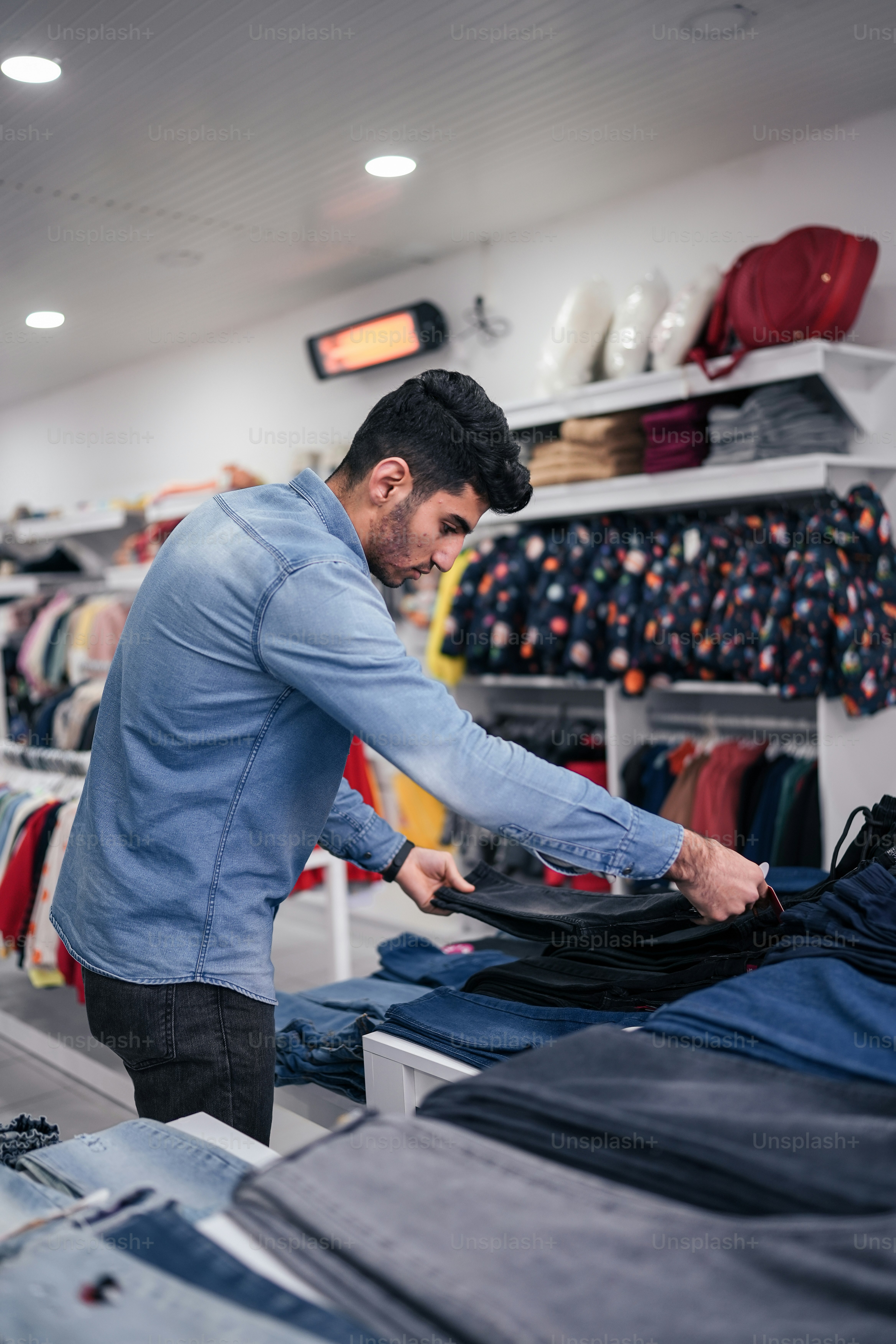 a man ironing clothes in a clothing store