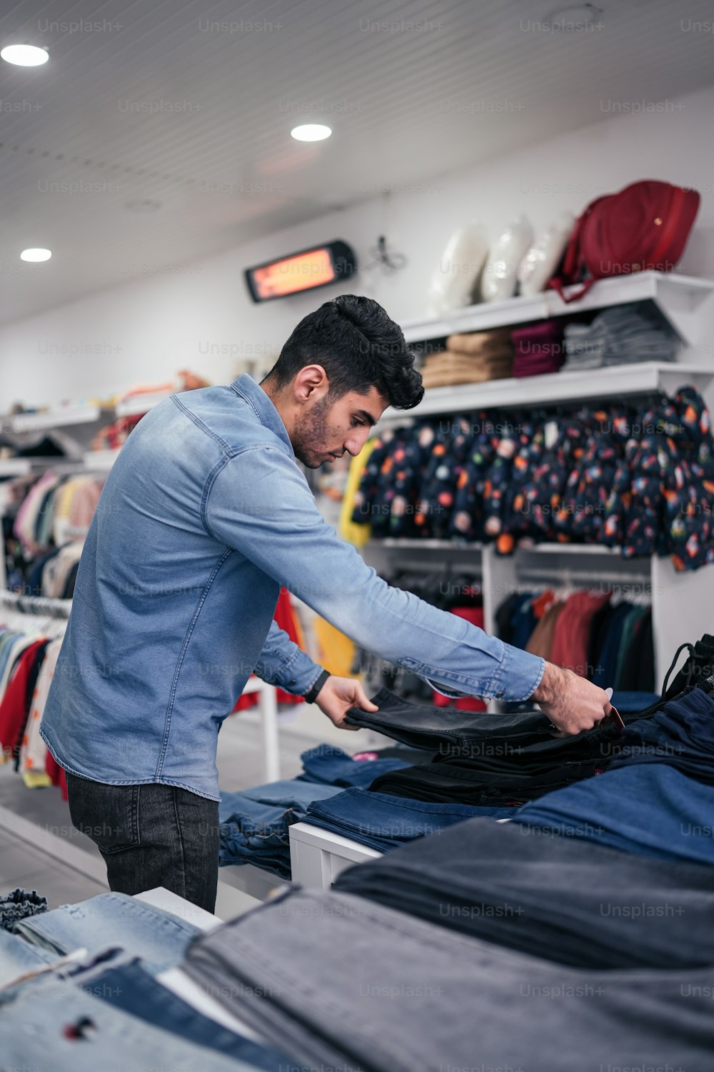a man ironing clothes in a clothing store